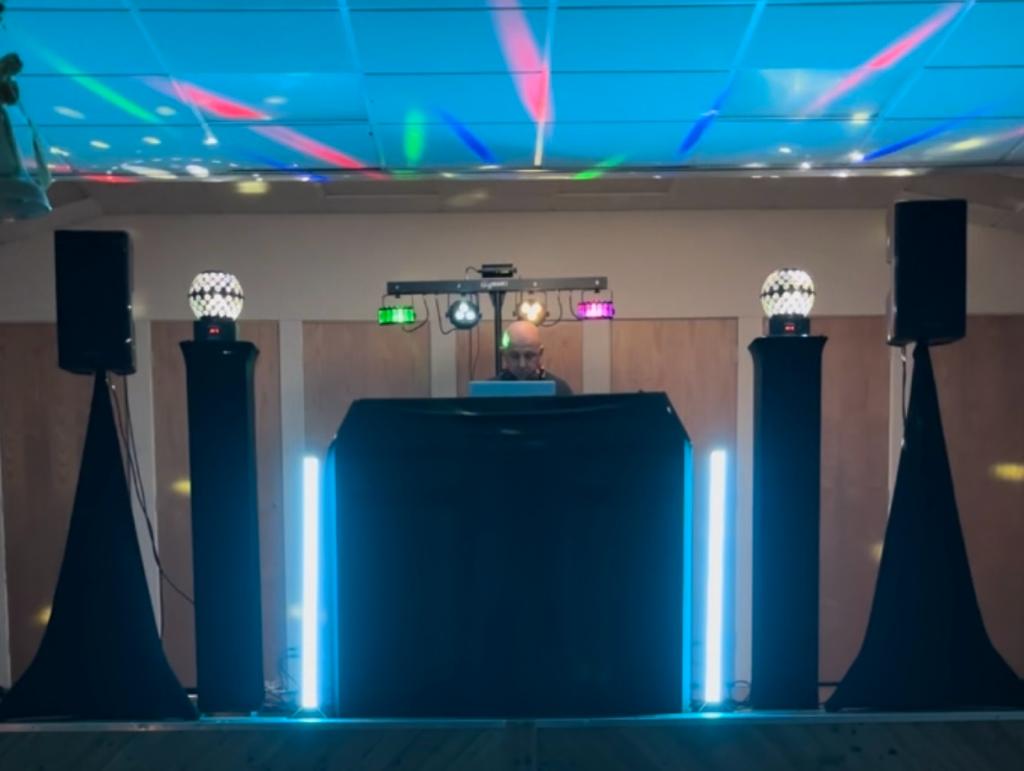 Dj Booth with black covers and pulse lights with two speakers.