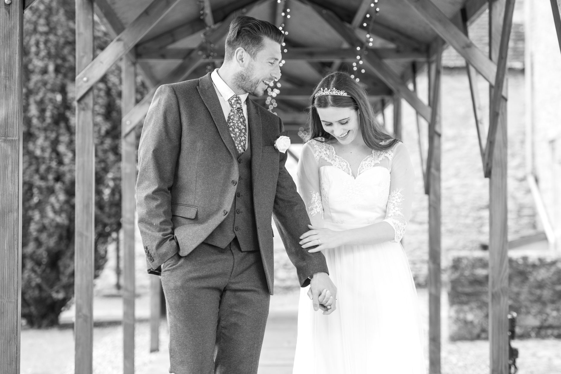 candid photo of bride and groom walking and holding hands, laughing and smiling