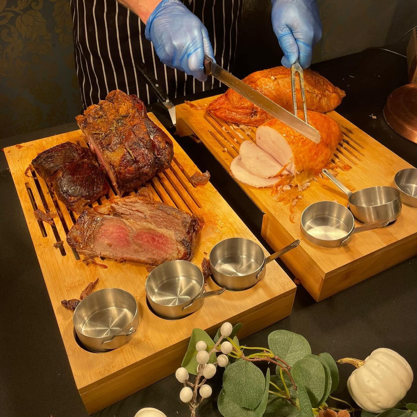 Server carving roast meats at a wedding buffet station