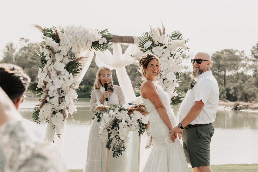 white wedding outdoors with celebrant bride and groom