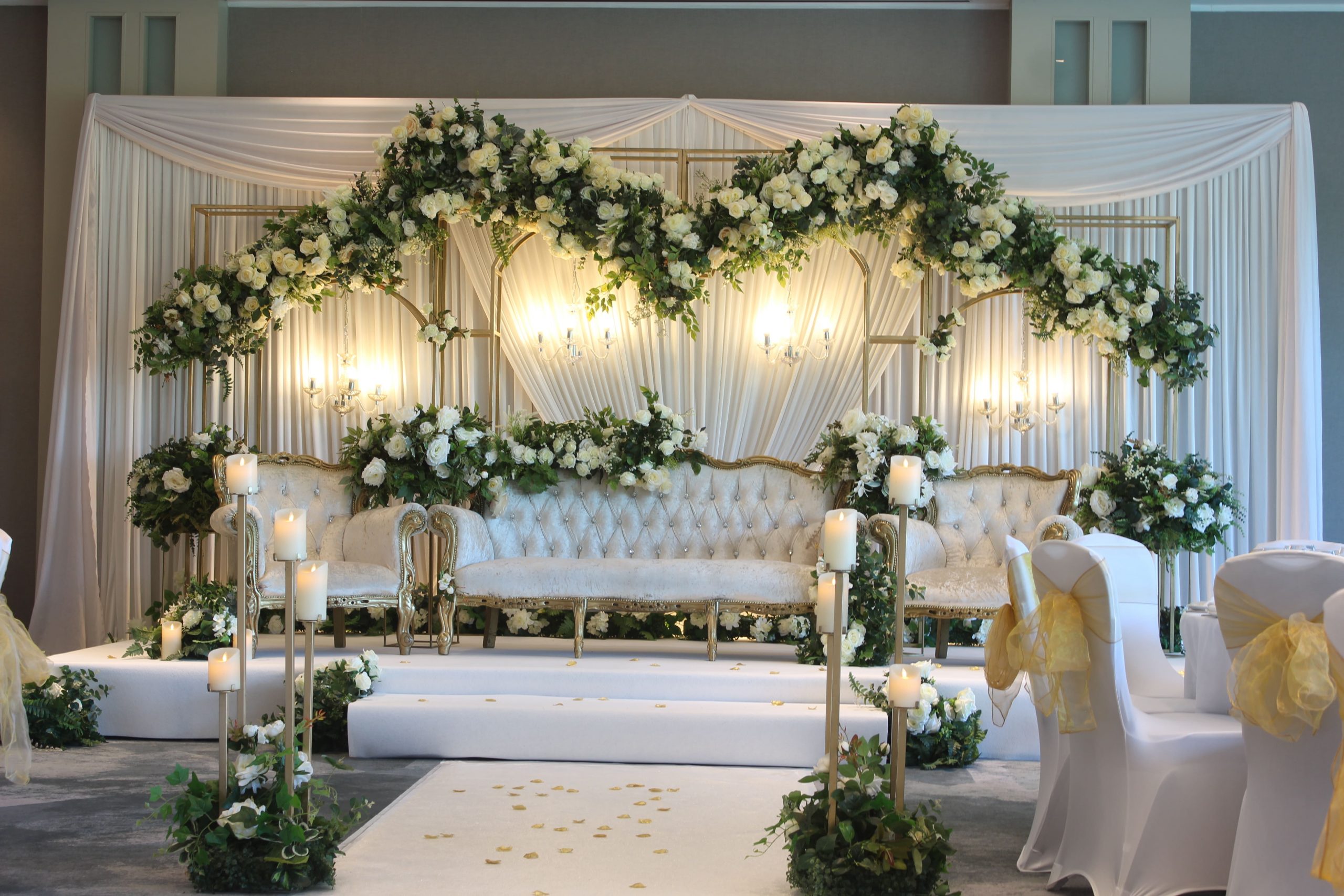 bridal couch decorated with floral arches