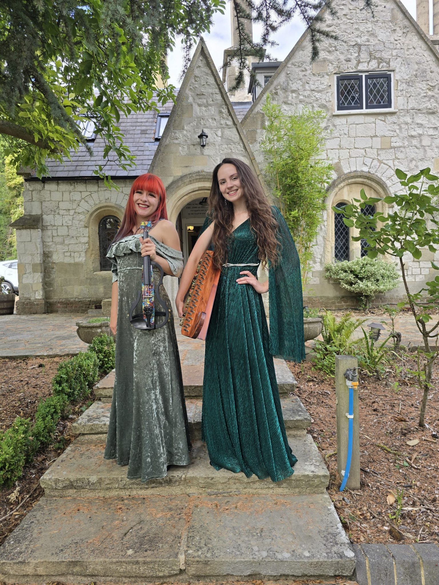 Violinist and kankles player at an outdoor event.