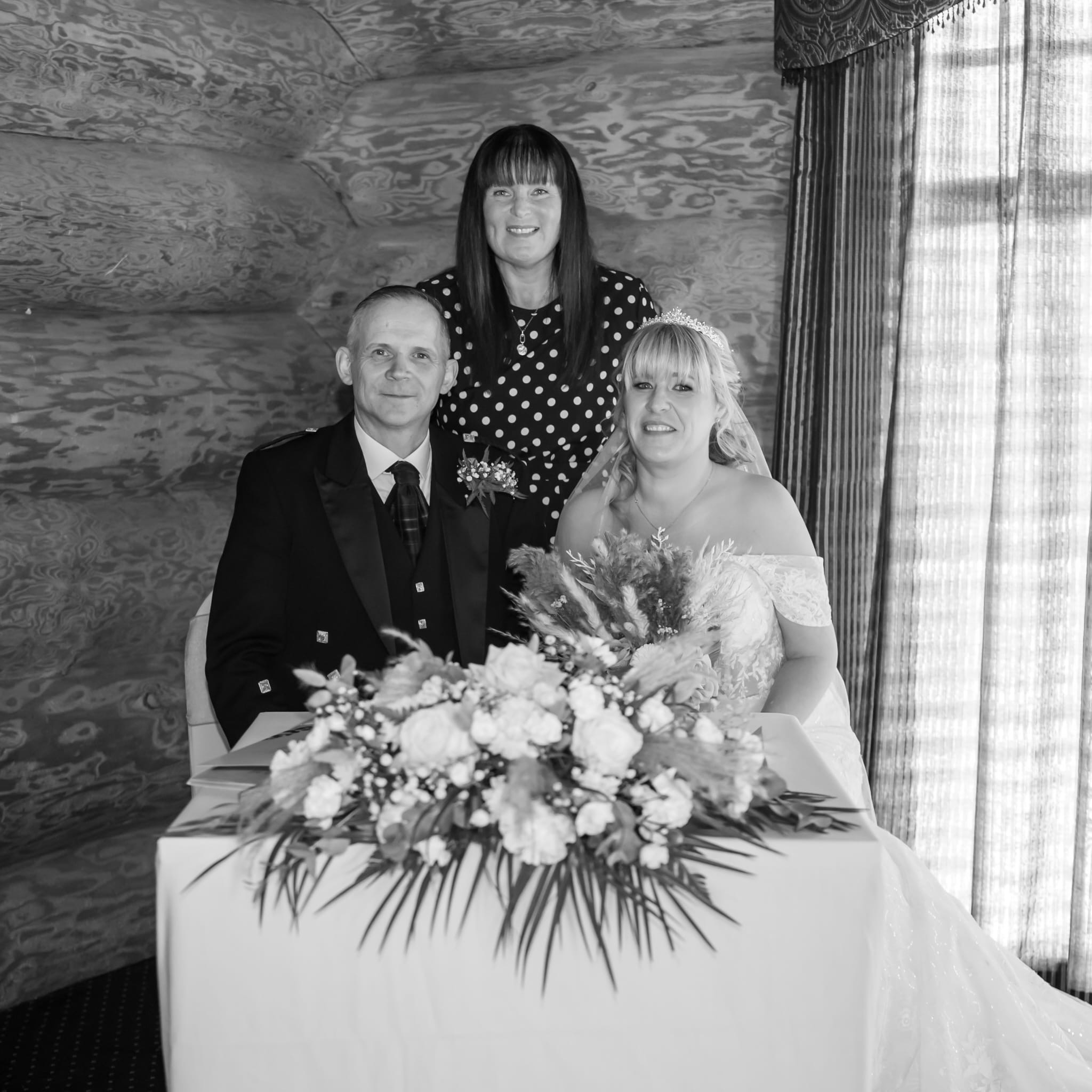 bridal couple with celebrant and flowers