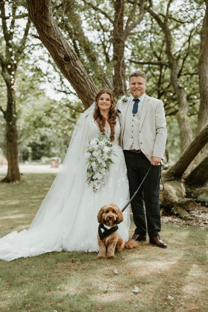 bride and groom with dog in venue grounds