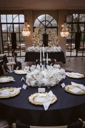 Luxury wedding styling at Woodlands Hotel in Leeds, Yorkshire by Love Stories Events featuring elegant black and white wedding decor, romantic candlelit tablescape styling, gold charger plates, luxury floral centrepieces, monochrome reception design and statement crystal chandeliers. Editorial Yorkshire wedding inspiration for couples searching luxury wedding stylist Leeds, wedding decor Yorkshire, black tie wedding styling, wedding table decor ideas, romantic reception styling, Harrogate wedding stylist and modern luxury wedding inspiration.