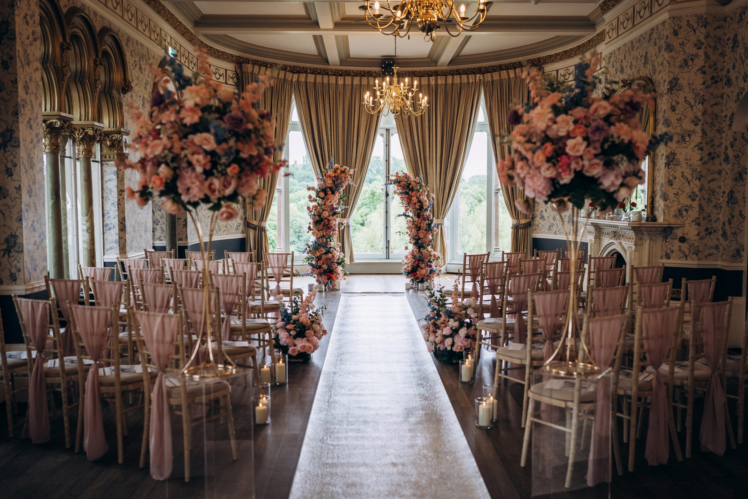 Luxury Bridgerton wedding décor and venue styling at Rushpool Hall featuring pastel floral ceremony arches, romantic aisle meadow flowers, blush chiffon draping, candlelit wedding aisle styling and editorial English garden-inspired florals. Yorkshire wedding stylist for luxury weddings in Leeds, York and Harrogate creating timeless wedding ceremony styling, romantic floral installations, luxury faux florals and high-end wedding décor inspired by Bridgerton elegance. This one is loaded for searches like Bridgerton wedding styling, Rushpool Hall wedding decor, Yorkshire wedding stylist, luxury ceremony flowers, English garden wedding inspiration.