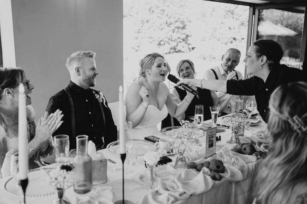 bride singing with guests laughing