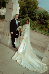 Elegant wedded couple looking over their shoulder, amongst granite pillars Brighton